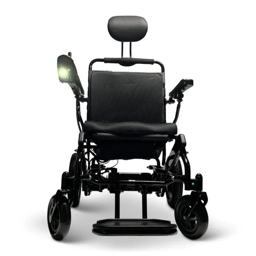 Front view of a Majestic power wheelchair with the ComfyGo headlight turned on and glowing at the armrest