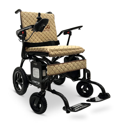 Front angled view of the ComfyGO Phoenix Carbon electric wheelchair in Coffee color featuring a lightweight carbon fiber frame, quilted padded seating, joystick controller, foldable design, and compact travel-ready mobility system.