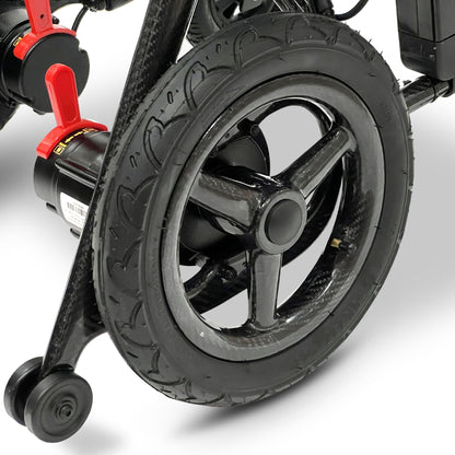 Close-up of the ComfyGO Phoenix Carbon electric wheelchair rear wheel, carbon fiber frame, and suspension system with durable treaded tire and compact folding wheelchair design.