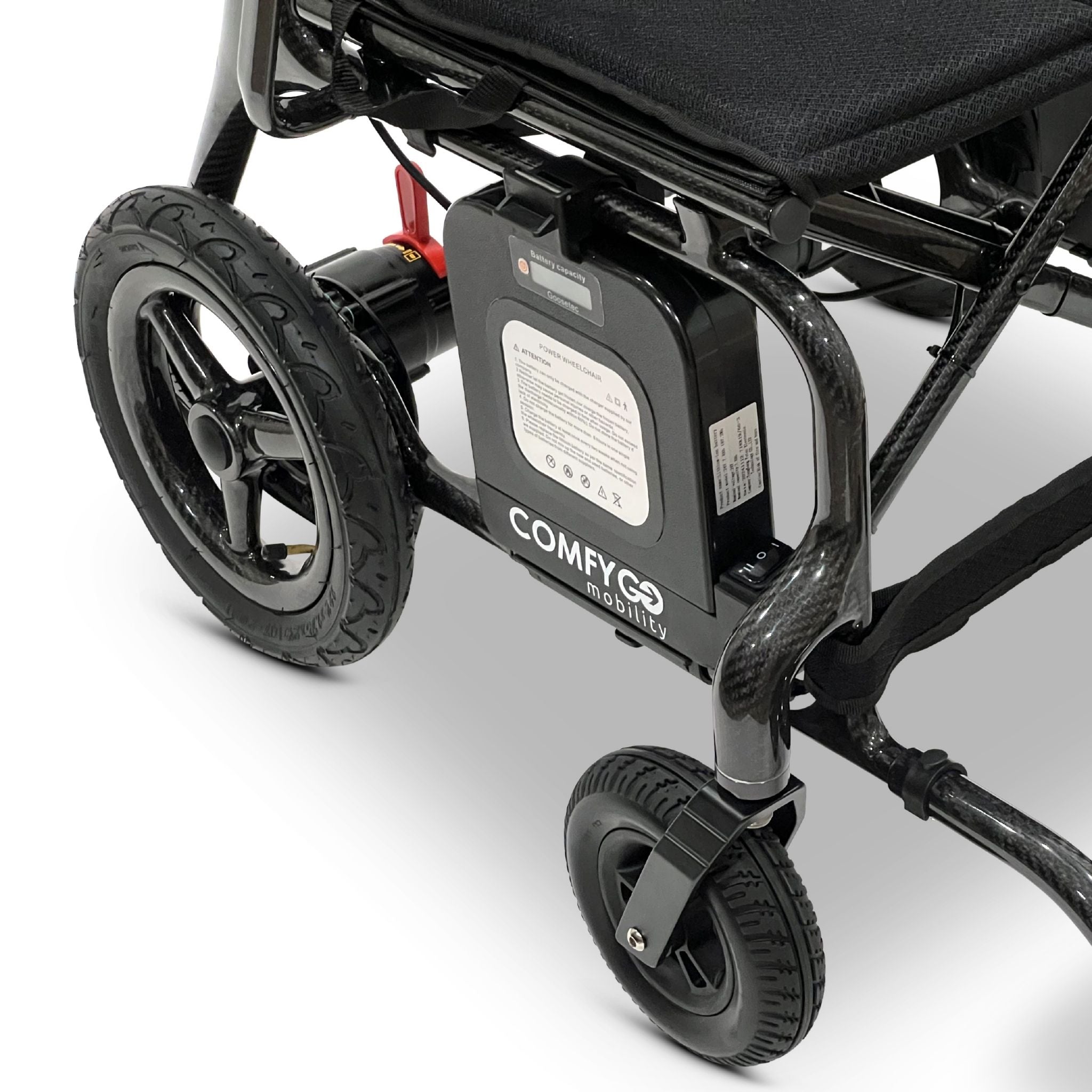 Rear close-up of the ComfyGO Phoenix Carbon electric wheelchair showing removable lithium battery system, carbon fiber frame, rear wheel assembly, and compact folding power wheelchair design.