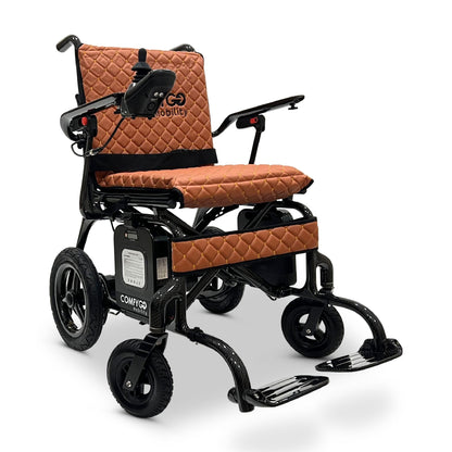 Front angled view of the ComfyGO Phoenix Carbon electric wheelchair in Taba color featuring a lightweight carbon fiber frame, quilted seating, joystick controller, foldable design, and travel-ready powered mobility system.