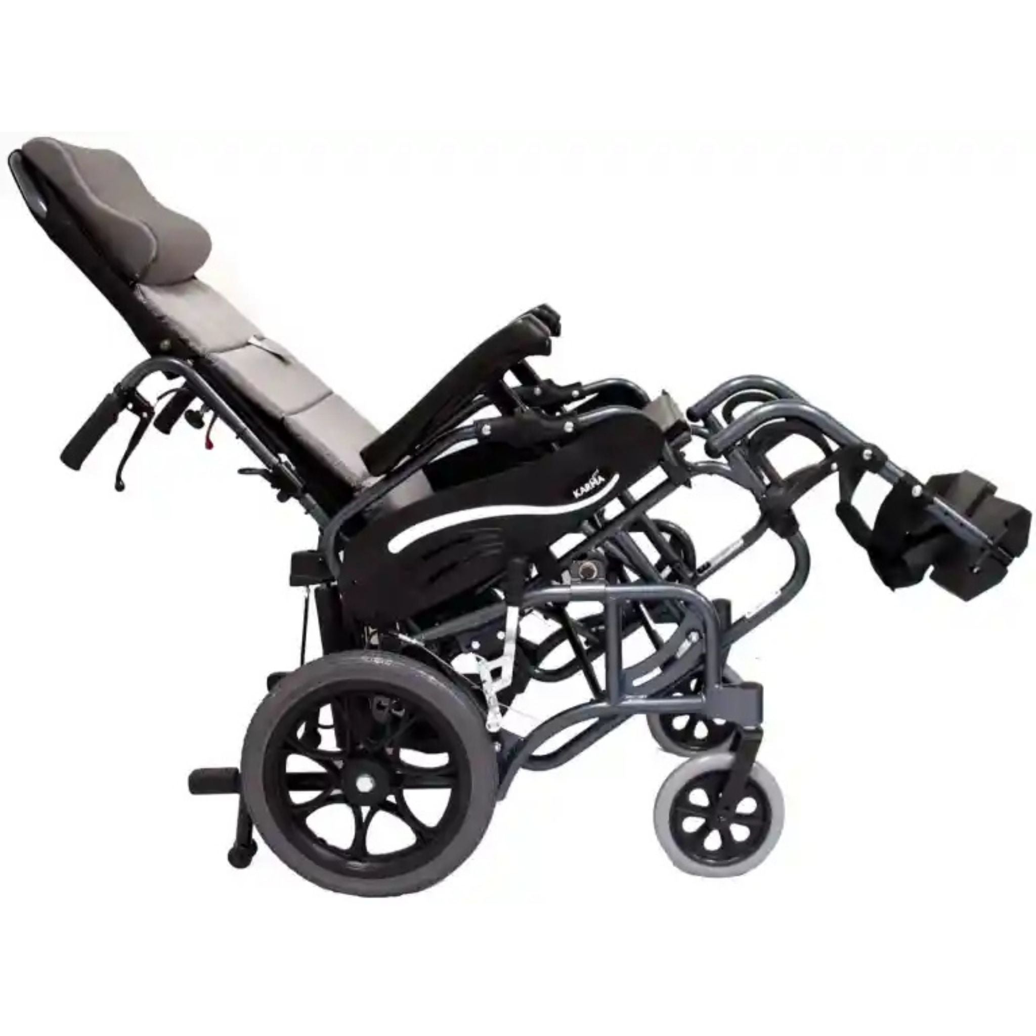 Side view of the Karman VIP-515-TP tilt-in-space reclining wheelchair with elevated leg rests, padded headrest, and reclining backrest shown in a fully tilted position on a white background