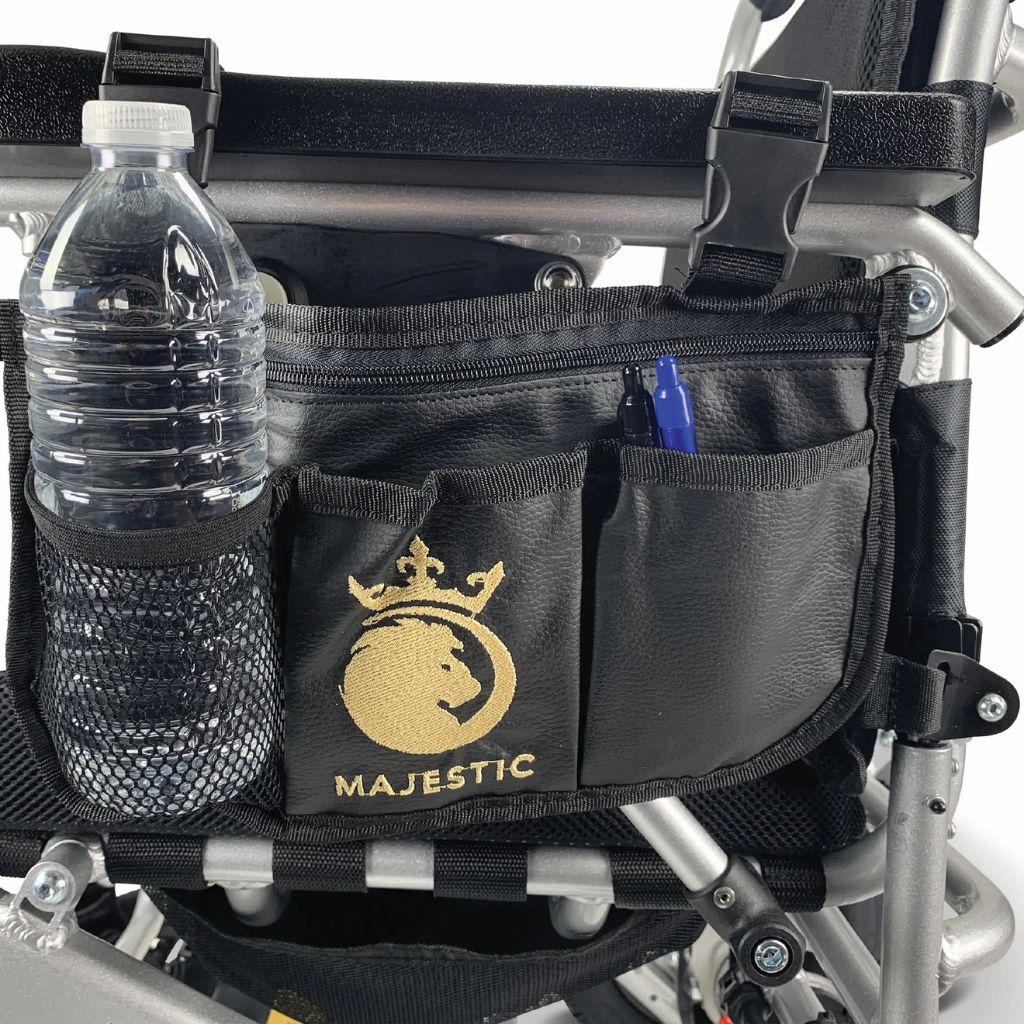 Majestic multipurpose bag strapped to a wheelchair frame, holding a water bottle in the mesh pocket and pens in the front pocket