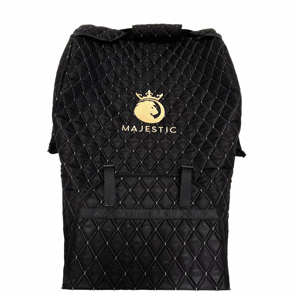 Empty Majestic quilted travel bag laid flat, showing the gold logo, front pocket, and clip-on straps