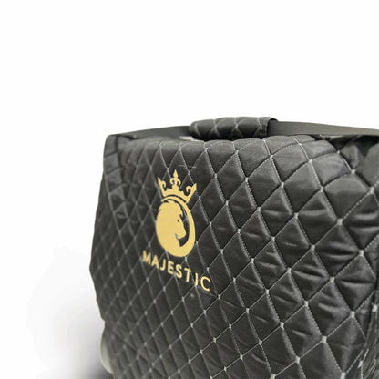 Close-up of the Majestic travel bag's diamond-quilted fabric, stitching, and gold embroidered logo