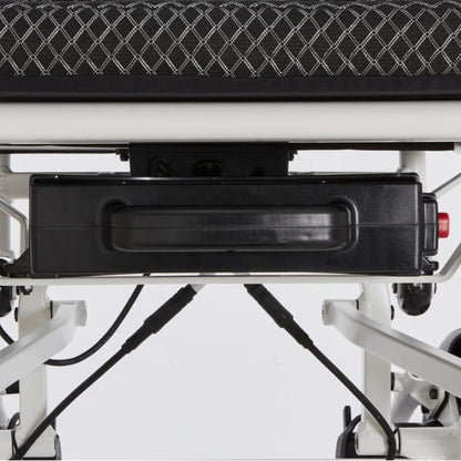 Close-up of the removable lithium battery secured under the seat of the OAS Air Pro 2027 electric wheelchair with its new battery cover