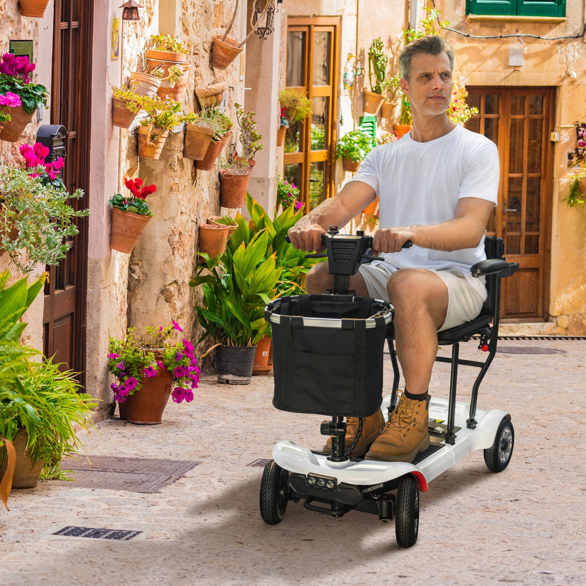 Man riding a white Paiseec D3 folding mobility scooter along a cobblestone village street
