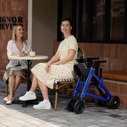 Paiseec FLEX R3 in Blue folded compactly beside two women at an outdoor café table