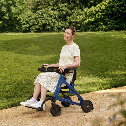 Woman riding the Paiseec FLEX 3-in-1 electric rollator wheelchair in Blue along a park path